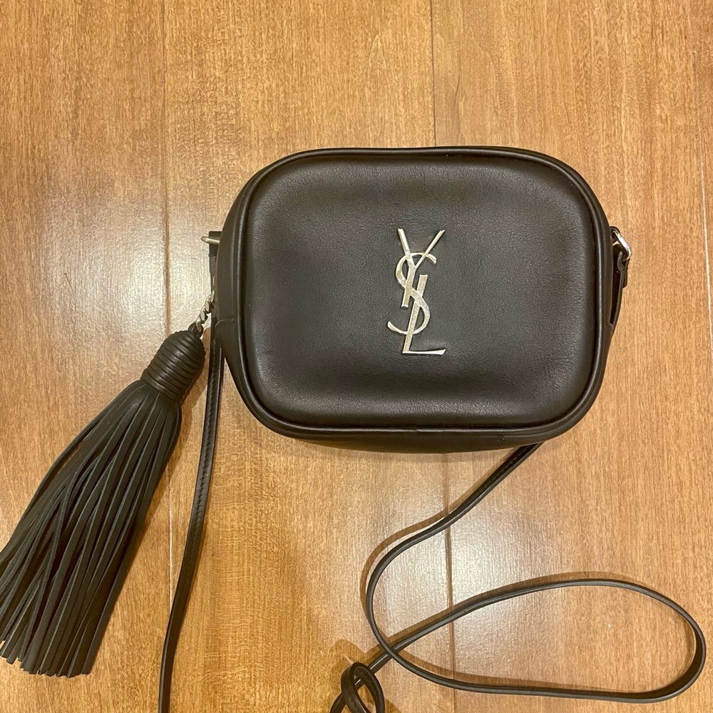 YSL Baby Lou Camera Bag is crafted of calfskin leather in black.